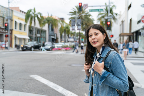 blurred background asian Korean woman carrying backpack is looking for road signs to find her way.