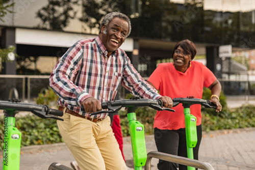 Cheerful senior couple enjoying with each other holding push scooters