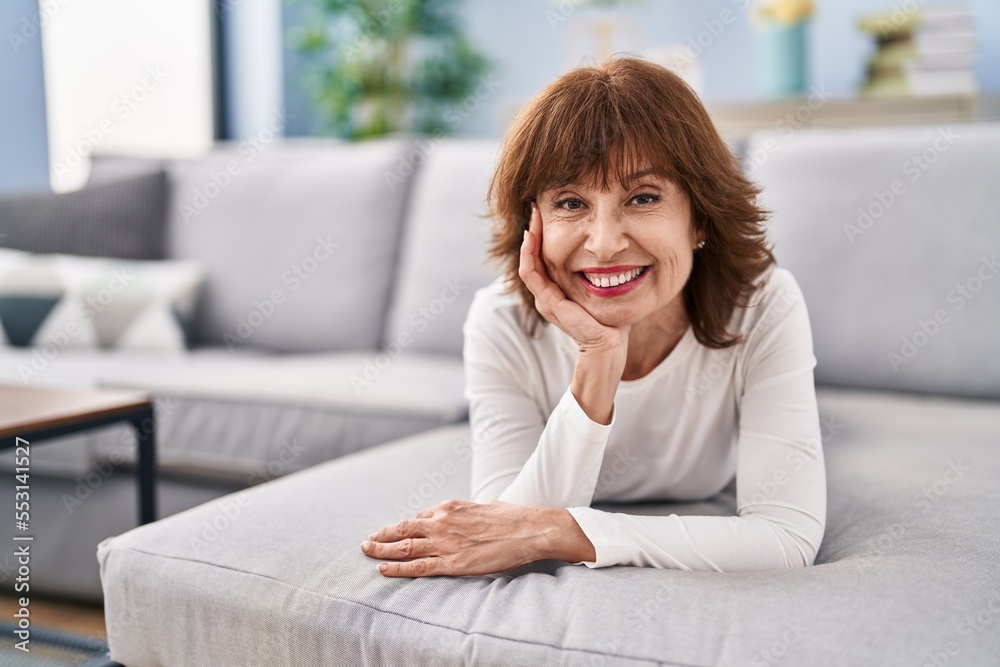 Middle age woman smiling confident lying on sofa at home Middle age woman smiling confident lying on sofa at home