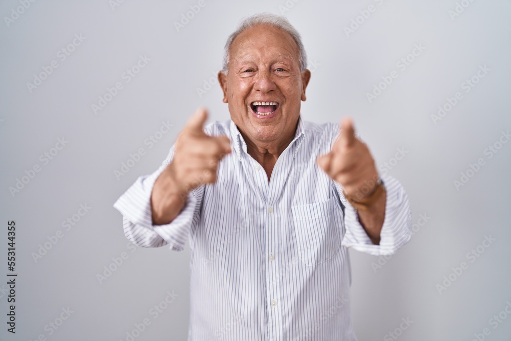 Senior man with grey hair standing over isolated background pointing to you and the camera with fingers, smiling positive and cheerful Senior man with grey hair standing over isolated background pointing to you and the camera with fingers, smiling positive and cheerful