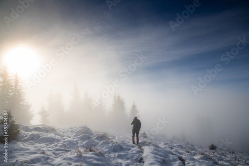 man trekking in foggy winter landscape in the mountains © Melinda Nagy