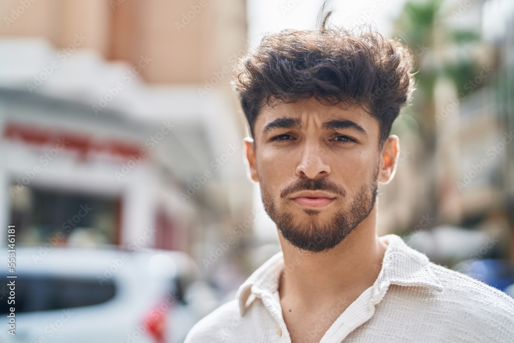 Young arab man with relaxed expression standing at street Young arab man with relaxed expression standing at street