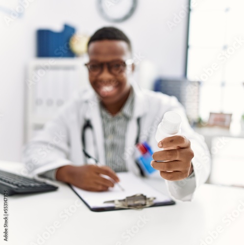 Young african man working as doctor writing pills prescription at medical clinic