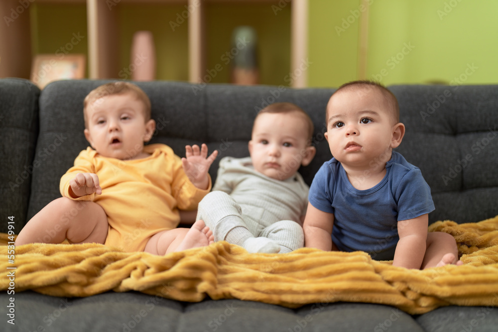 Group of toddlers sitting on sofa at home Group of toddlers sitting on sofa at home