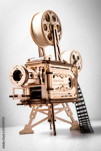 wooden model of a cinema projector, old style movie projector over light grey background. High quality photo