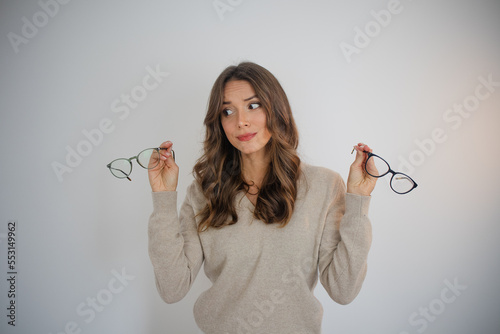 Person holding eyeglasses feeling undecided doubt choice
