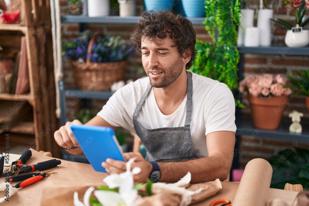 Young hispanic man florist smiling confident using touchpad at flower shop Young hispanic man florist smiling confident using touchpad at flower shop