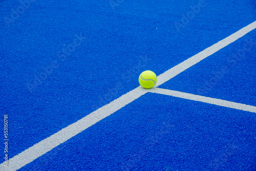 a ball on a blue paddle tennis court line © Vic