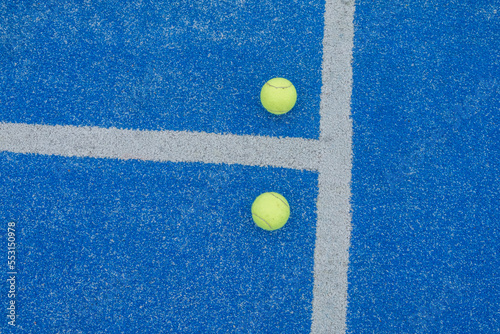 two balls on the surface of a blue paddle tennis court © Vic