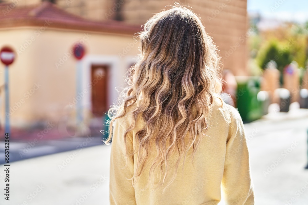 Young woman standing on back view at street Young woman standing on back view at street