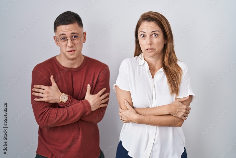 Mother and son standing together over isolated background shaking and freezing for winter cold with sad and shock expression on face Mother and son standing together over isolated background shaking and freezing for winter cold with sad and shock expression on face