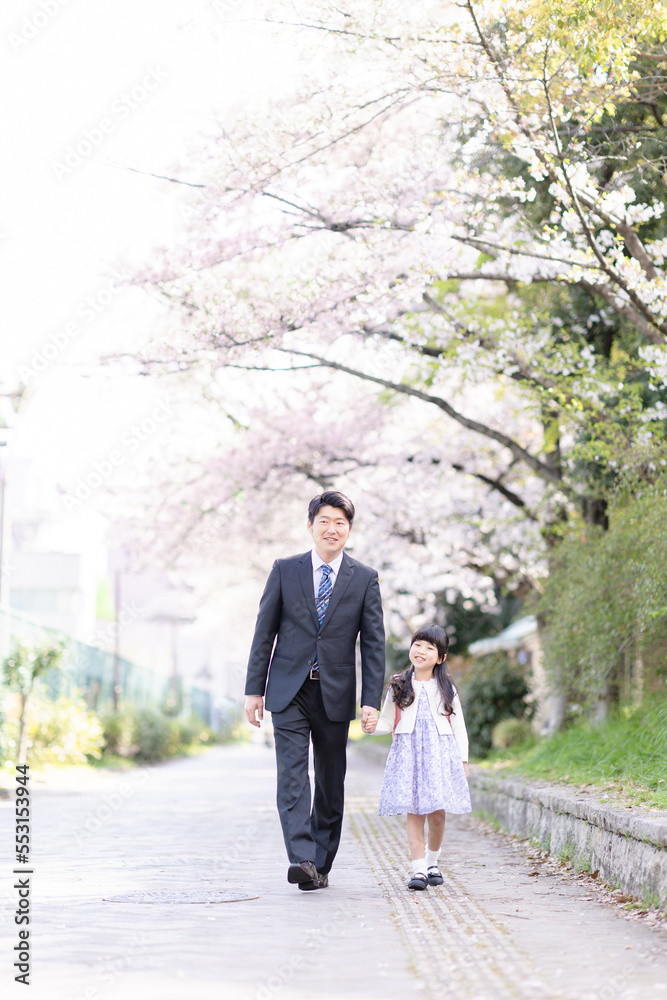 Fototapeta premium ランドセルを背負った女の子とスーツを着た父親