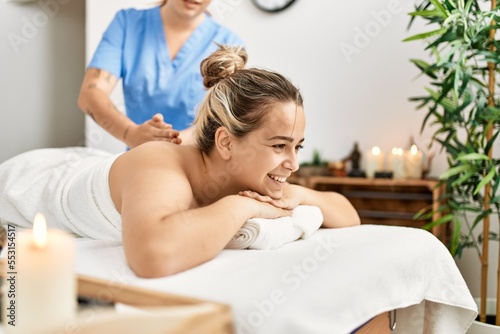 Woman couple smiling confident having back massage at beauty center photo