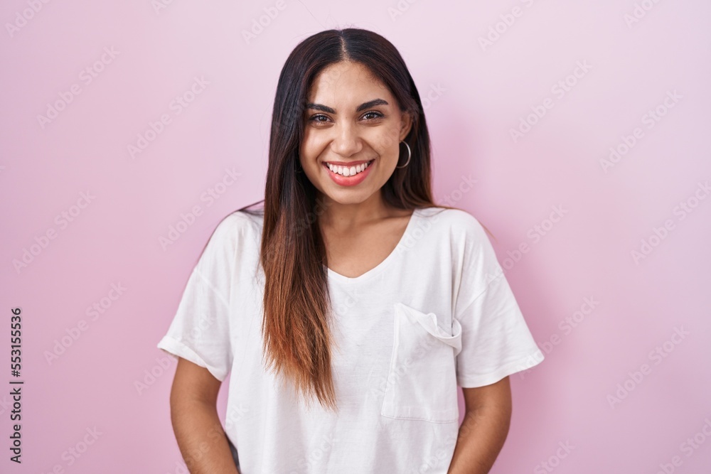 Young arab woman standing over pink background with a happy and cool smile on face. lucky person. Young arab woman standing over pink background with a happy and cool smile on face. lucky person.