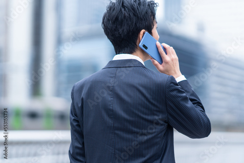 電話をするビジネスマンの後ろ姿