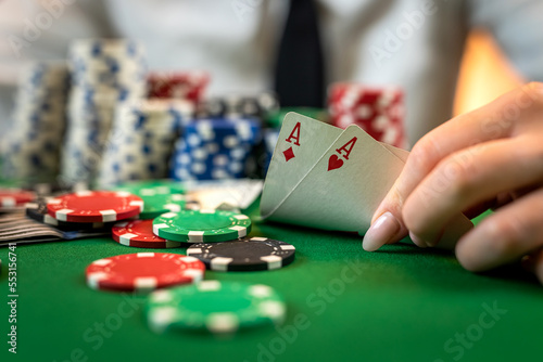 Greedy poker player after winning the game takes chips on a hundred dollar bill from the table.