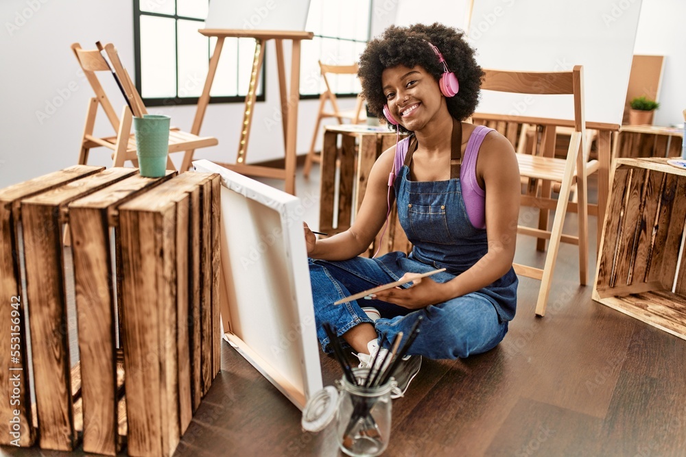 Young african american woman listening to music drawing at art studio