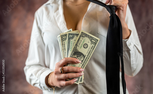 woman holding pile of dollars happy in discreet shirt isolated on plain background.