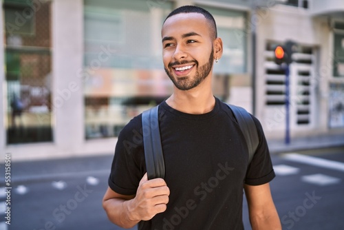 Young african american man smiling confident wearing backpack at street