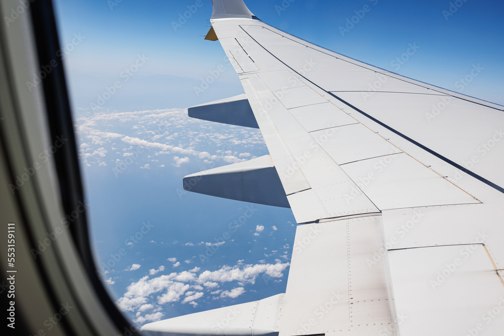 View from Inside an Aircraft: Window of the Cabin, White Airplane Wing and Clouds View from Inside an Aircraft: Window of the Cabin, White Airplane Wing and Clouds