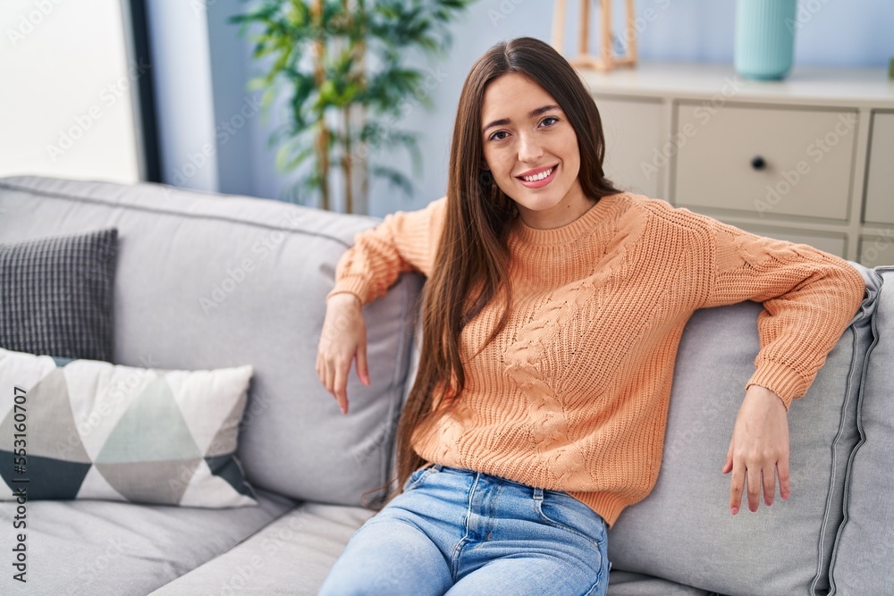 Young beautiful hispanic woman smiling confident sitting on sofa at home Young beautiful hispanic woman smiling confident sitting on sofa at home