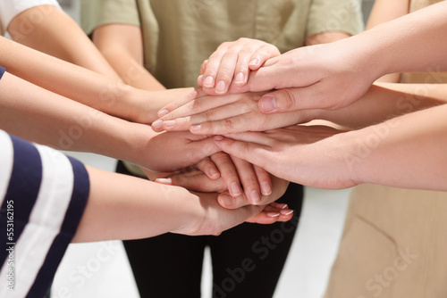 Group of people holding hands together indoors  closeup. Unity concept