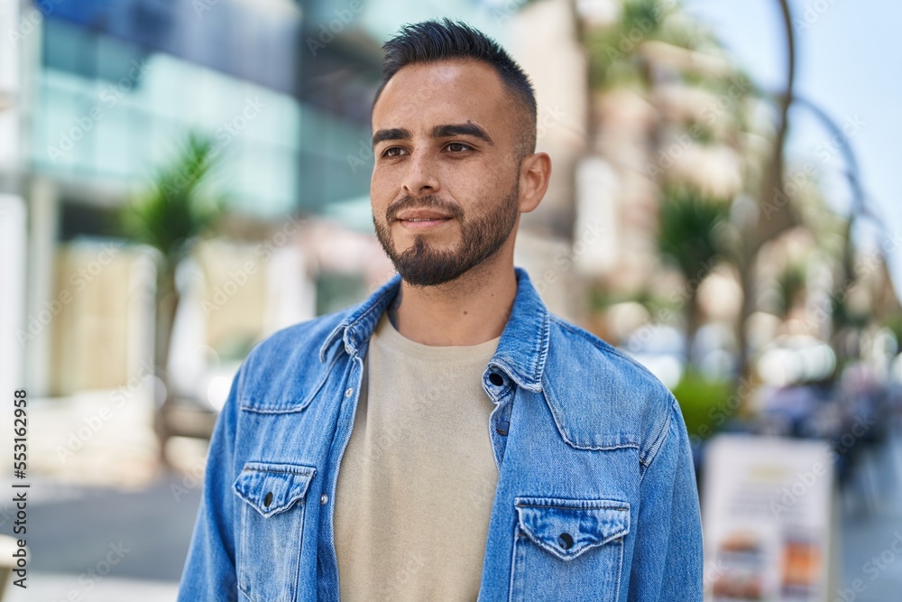 Young hispanic man smiling confident pointing with fingers at street