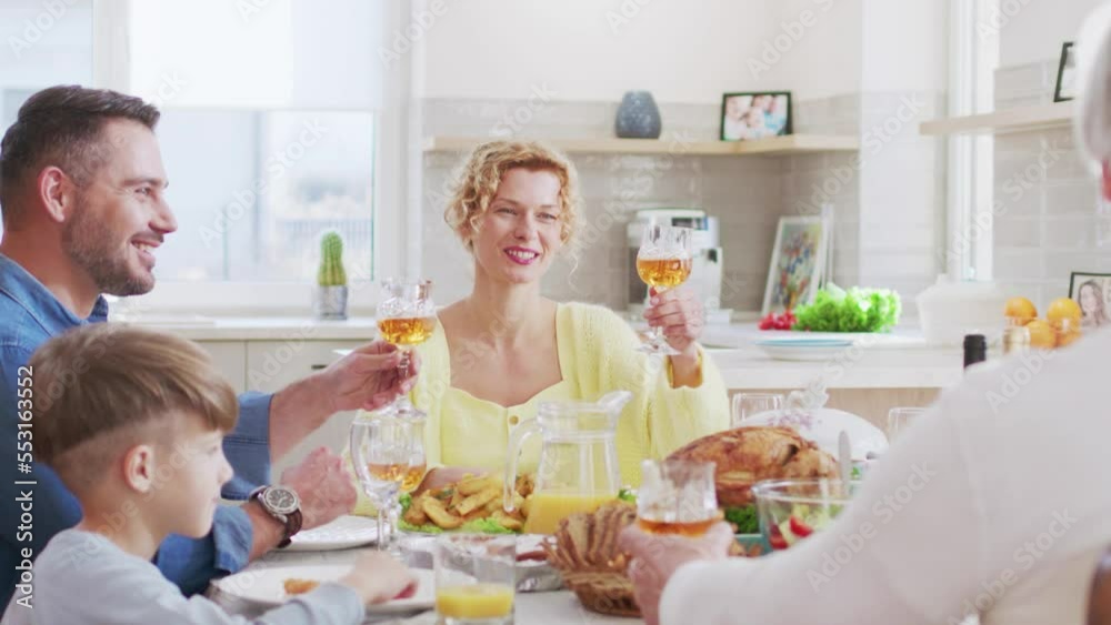 Happy family having family breakfast celebrating. Cheerful people raising toast sitting on table with tasty food talking smiling. Young people spending time together with kids. Family life concept. Happy family having family breakfast celebrating. Cheerful people raising toast sitting on table with tasty food talking smiling. Young people spending time together with kids. Family life concept.