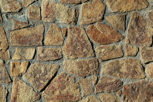 Texture of concrete wall decorated with stones as background  closeup