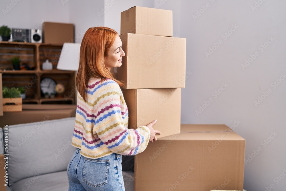 Young caucasian woman smiling confident holding packages at new home Young caucasian woman smiling confident holding packages at new home