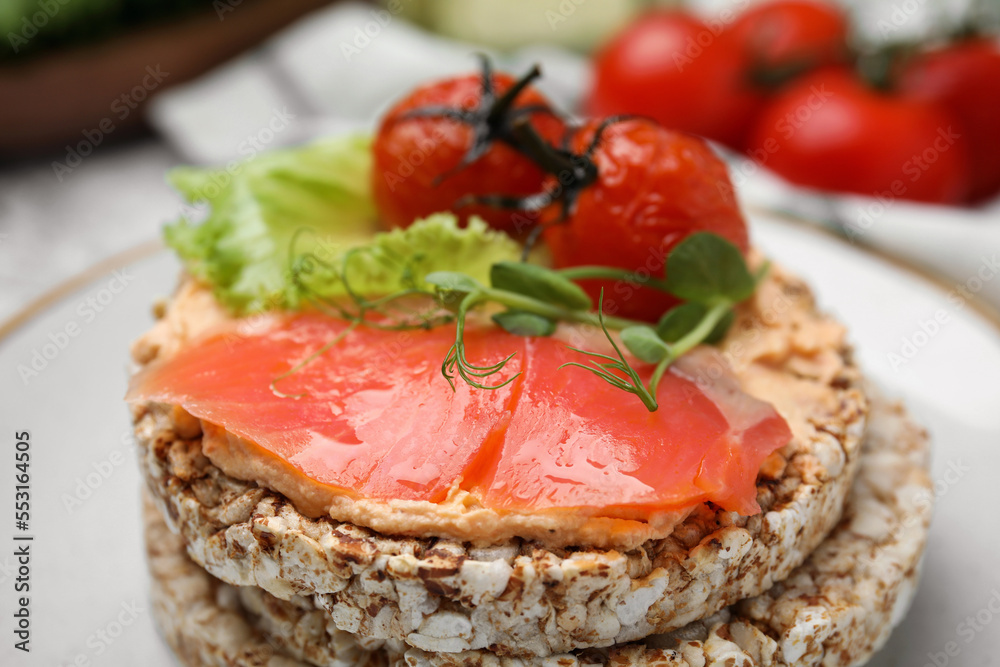 Crunchy buckwheat cakes with salmon, tomatoes and greens on plate, closeup Crunchy buckwheat cakes with salmon, tomatoes and greens on plate, closeup