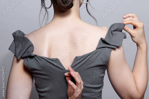 Billede på lærred Woman unzips the zipper on the dress