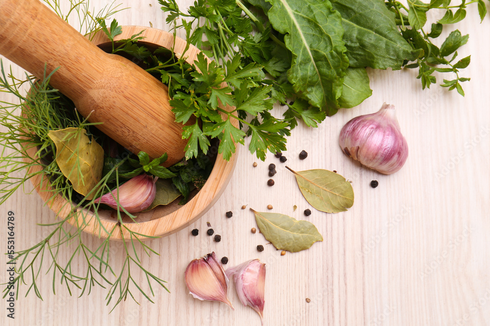 Mortar with pestle and different ingredients on wooden table, flat lay