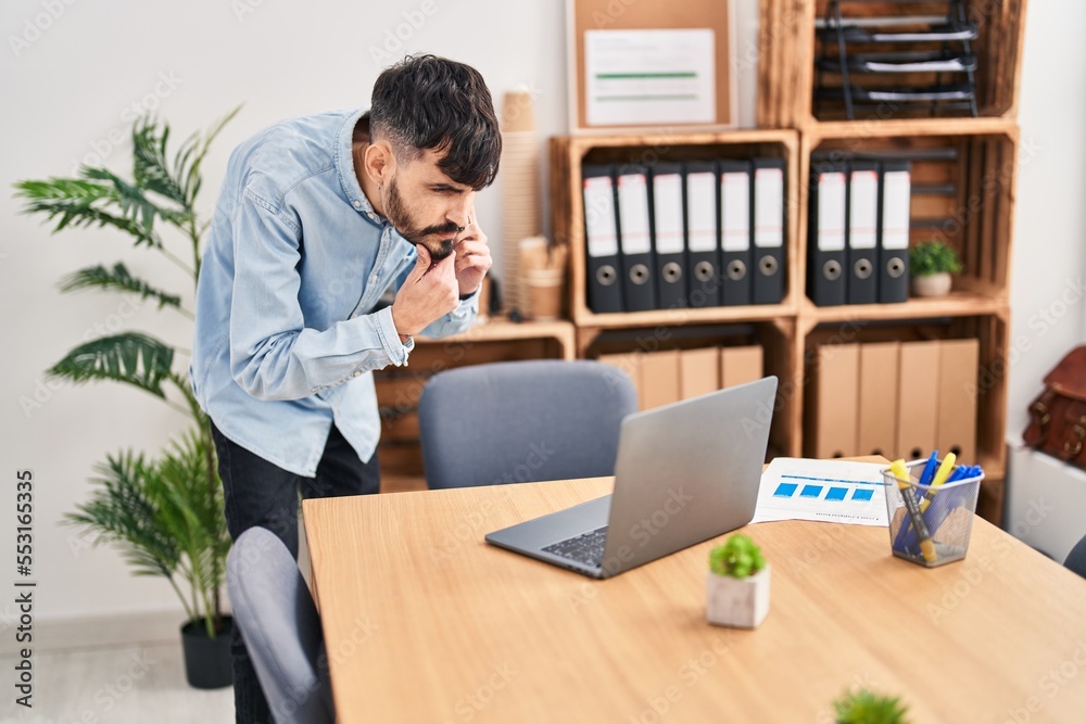 Young hispanic man business worker talking on smartphone using laptop at office Young hispanic man business worker talking on smartphone using laptop at office