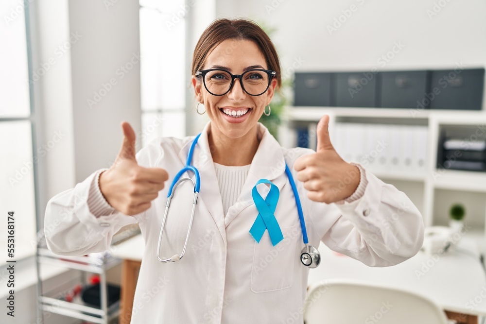 Young brunette doctor woman wearing stethoscope at the clinic success sign doing positive gesture with hand, thumbs up smiling and happy. cheerful expression and winner gesture. Young brunette doctor woman wearing stethoscope at the clinic success sign doing positive gesture with hand, thumbs up smiling and happy. cheerful expression and winner gesture.