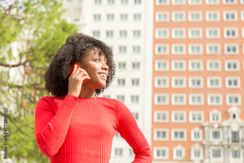 smiling young woman talking on the phone outdoors photo