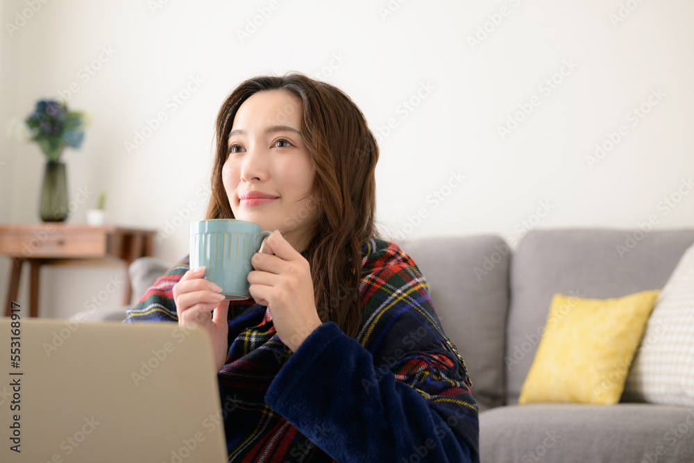 Asian woman drinking a hot beverage