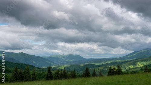 Summer mountain landscape timelapse moving clouds, far below, in the green valley, the small town of Kolochava, Carpathian Mountains, Pryslip pass Ukraine. photo