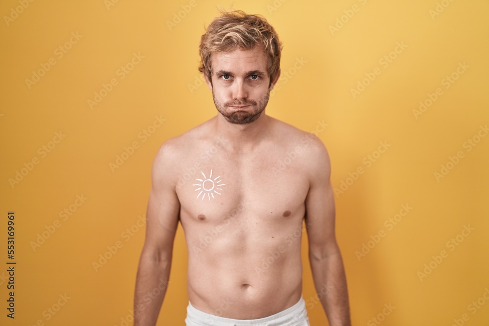 Caucasian man standing shirtless wearing sun screen puffing cheeks with funny face. mouth inflated with air, crazy expression.