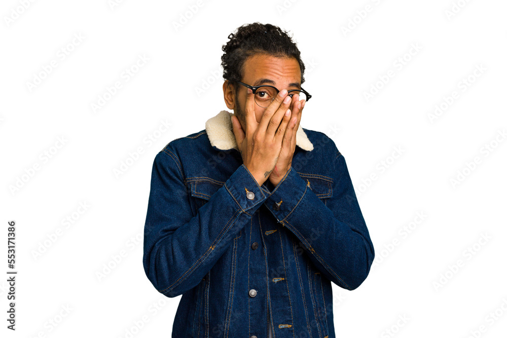 Young African American man isolated blink at the camera through fingers, embarrassed covering face. Young African American man isolated blink at the camera through fingers, embarrassed covering face.
