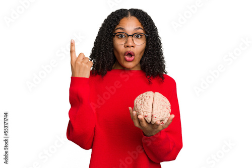 Young african american woman holding a brain model isolated having some great idea, concept of creativity.