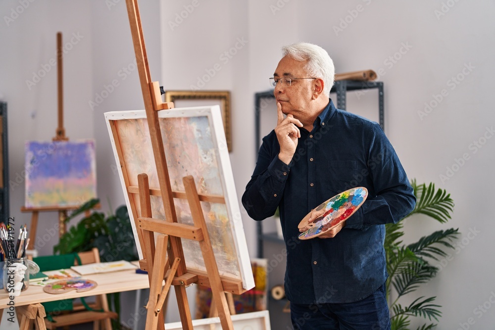 Senior man drawing with serious expression at art studio Senior man drawing with serious expression at art studio