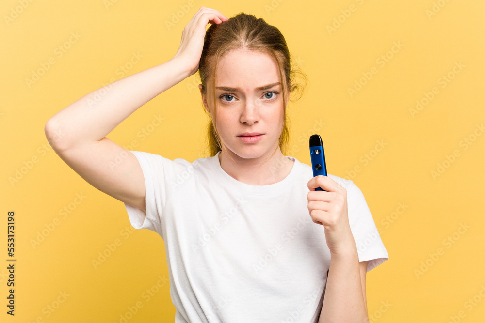 Young cute woman holding a vaper isolated on yellow background being shocked, she has remembered important meeting. Young cute woman holding a vaper isolated on yellow background being shocked, she has remembered important meeting.