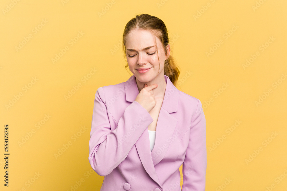 Young caucasian redhead woman isolated on yellow background suffers pain in throat due a virus or infection. Young caucasian redhead woman isolated on yellow background suffers pain in throat due a virus or infection.