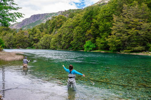 a woman is trying to fish trout in nahuel huapi lake, argentina photo