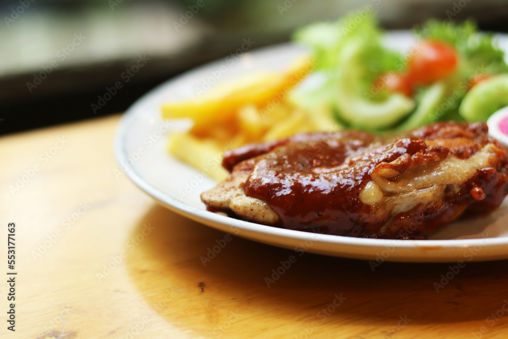 European food, chicken steak with french fries, vegetables and vinegar dressing on a table plate. European food, chicken steak with french fries, vegetables and vinegar dressing on a table plate.