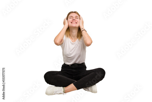 Young caucasian woman sitting on the floor cutout isolated