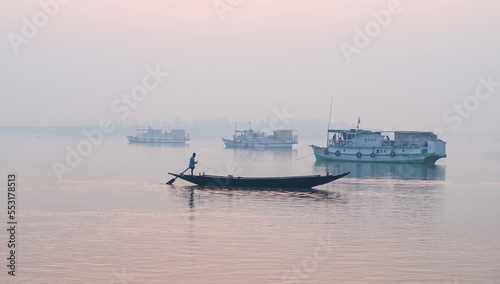 Sundarbans area  West Bengal India     February 12 2012  Boats in a foggy lagoon at sunrise.