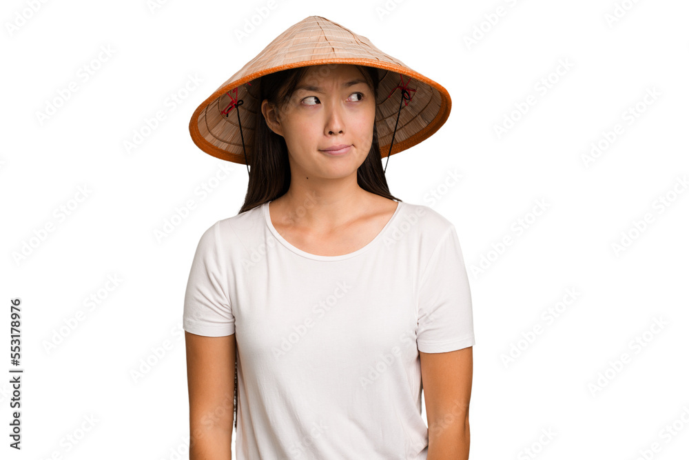 Young asian woman wearing a Vietnamese hat isolated confused, feels doubtful and unsure. Young asian woman wearing a Vietnamese hat isolated confused, feels doubtful and unsure.