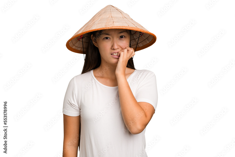 Young asian woman wearing a Vietnamese hat isolated biting fingernails, nervous and very anxious. Young asian woman wearing a Vietnamese hat isolated biting fingernails, nervous and very anxious.